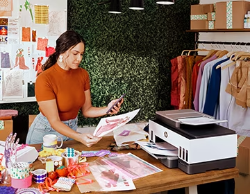 Mujer en su trabajo comparando la foto de su celular con la ...
