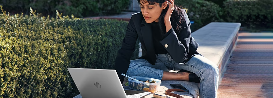 Chica trabajando en un parque con laptop HP